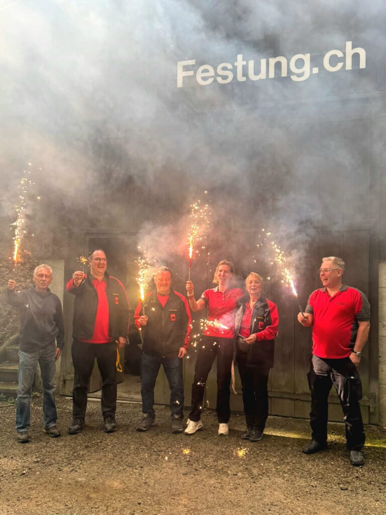 Team steht mit Partykerzen vor dem Kommandobunker
